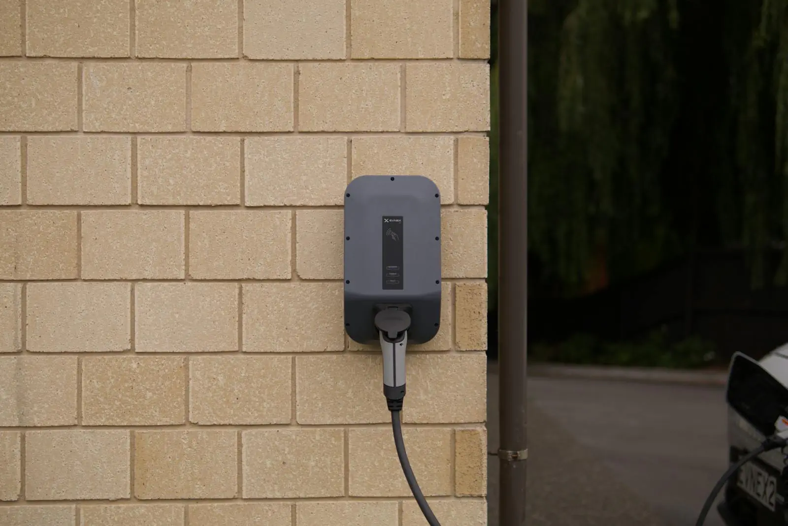 Hardwired vs plug-in EV charger outdoor wall-mounted charging station